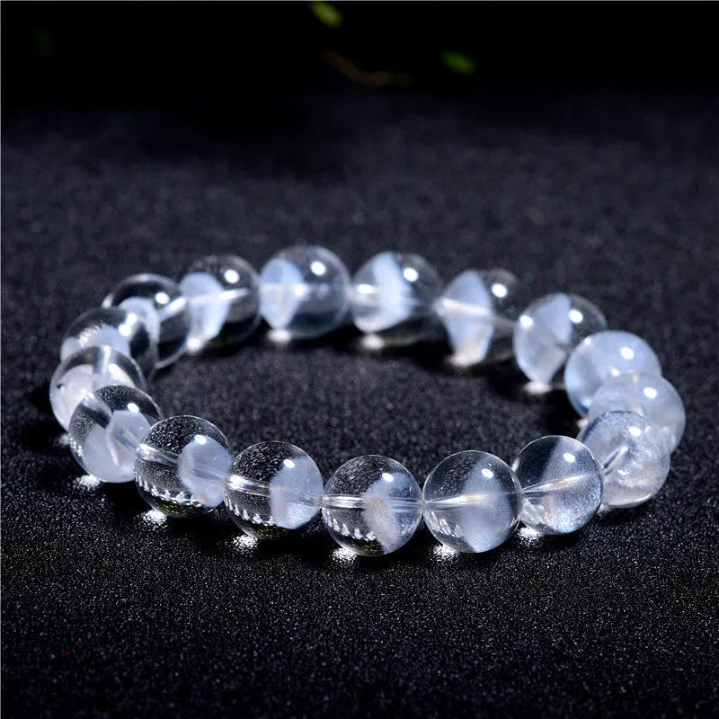 Women's white crystal pyramid bead bracelet with a silver ruyi charm on a white background.