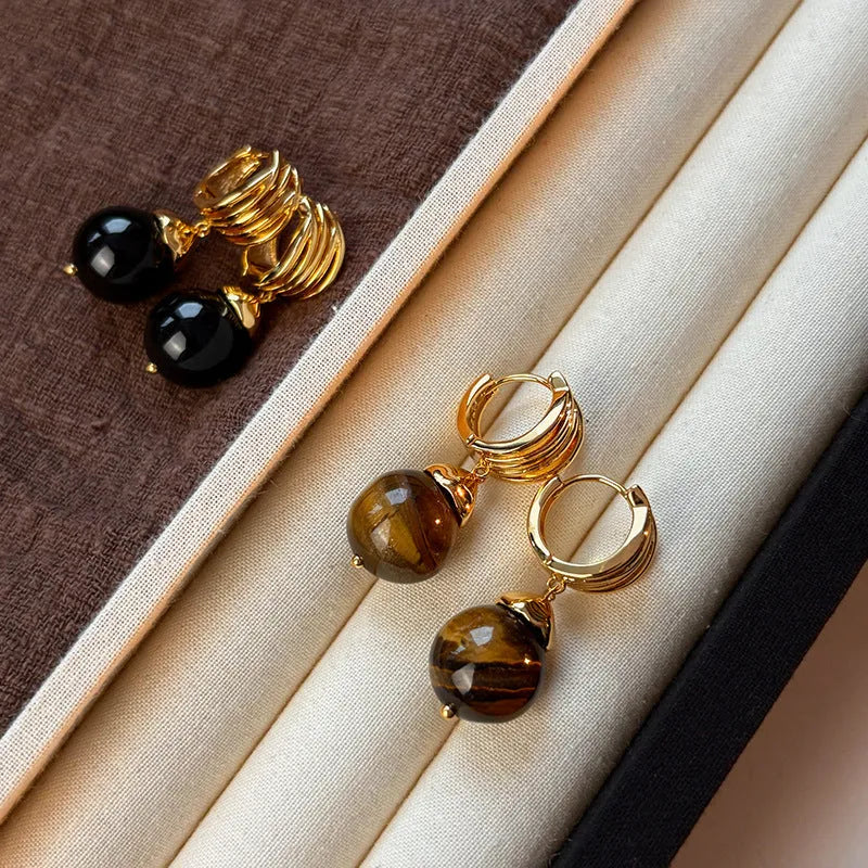 A pair of Fashion Maillard Tigereye earrings with a geometric shape and real gold plating, shown in brown and black colour options.
