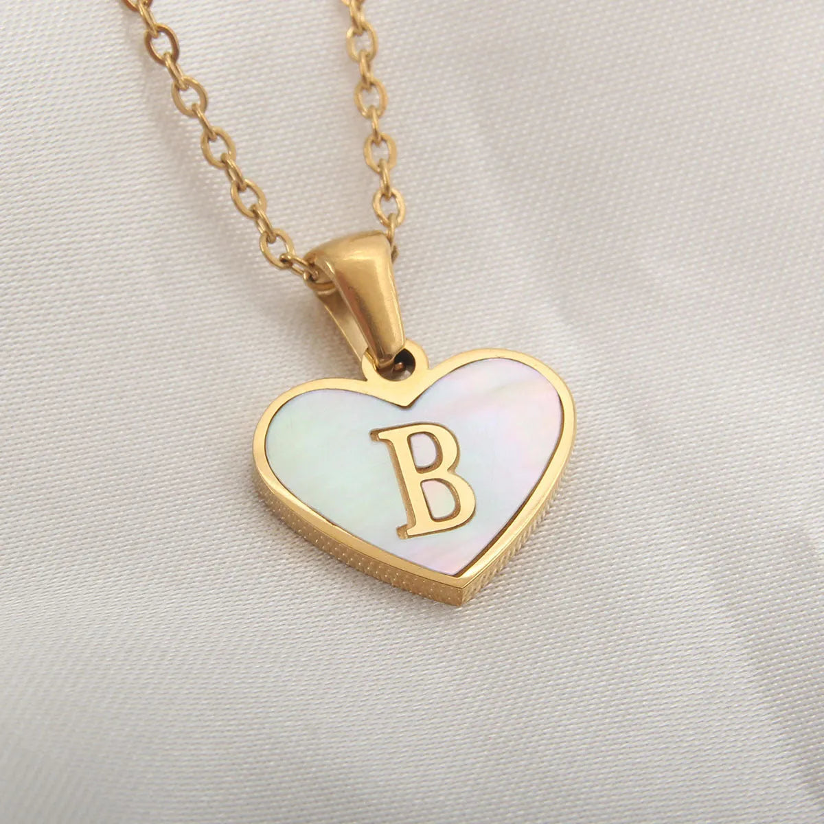 Gold heart necklace with white shell pendant and initial charm on 45cm adjustable chain
