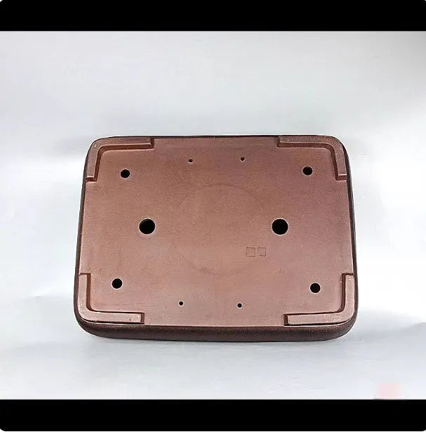Large handmade antique rectangular purple clay flower pot on a table.