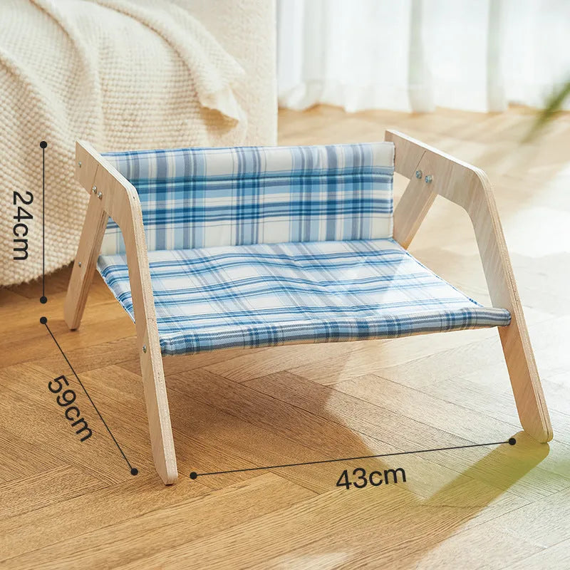 Wooden elevated cat hammock bed with a soft blue cloth sleeping mat, raised on wooden legs.