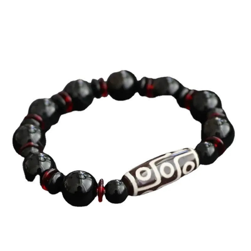 Black agate Dzi bead bracelet with hand-woven construction and geometry beads.