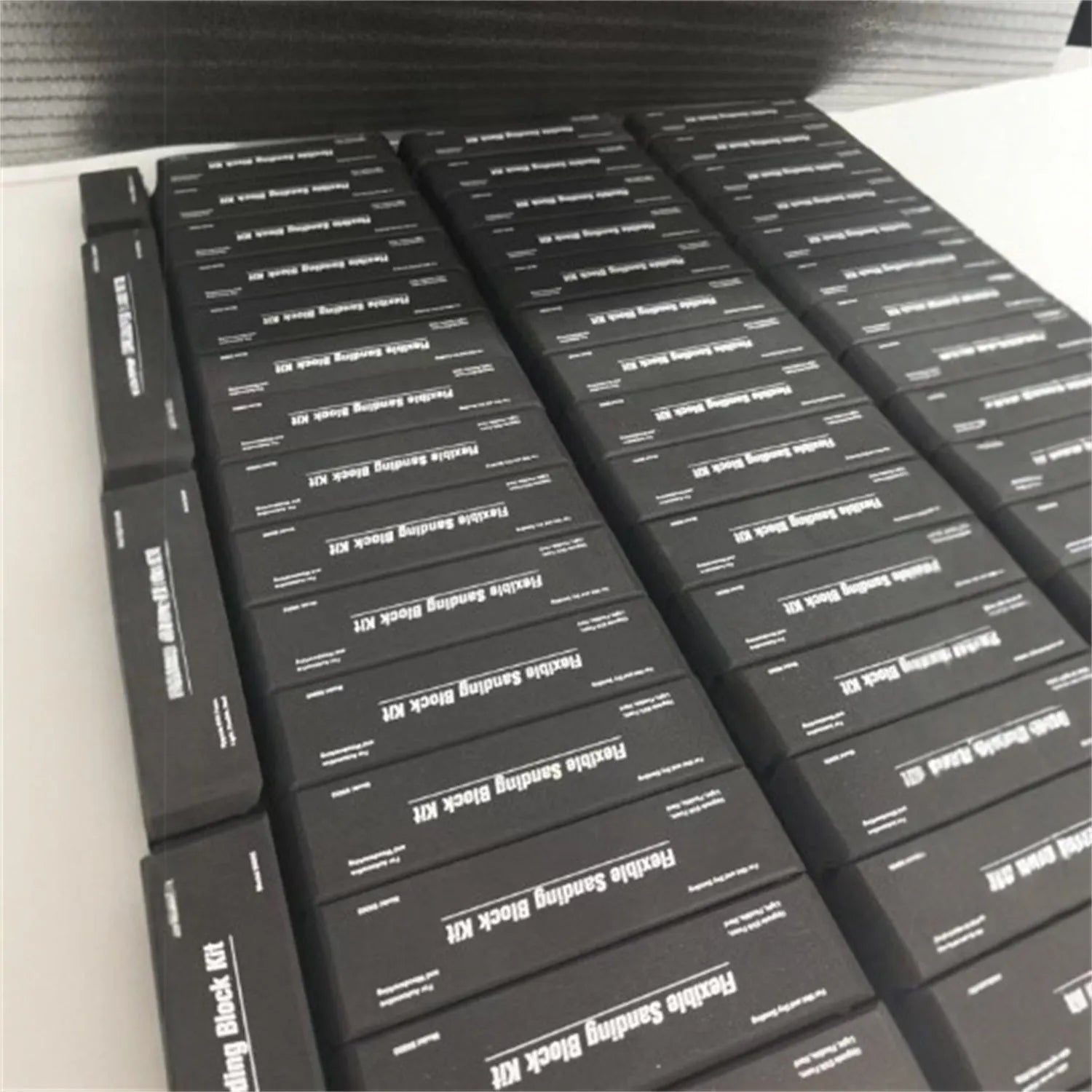 Set of seven black metal frosted blocks arranged together on a surface.