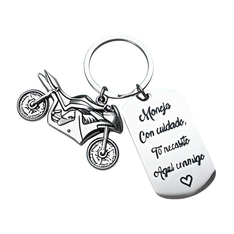 Stainless steel keychain with a motorcycle design presented on a velvet cloth.