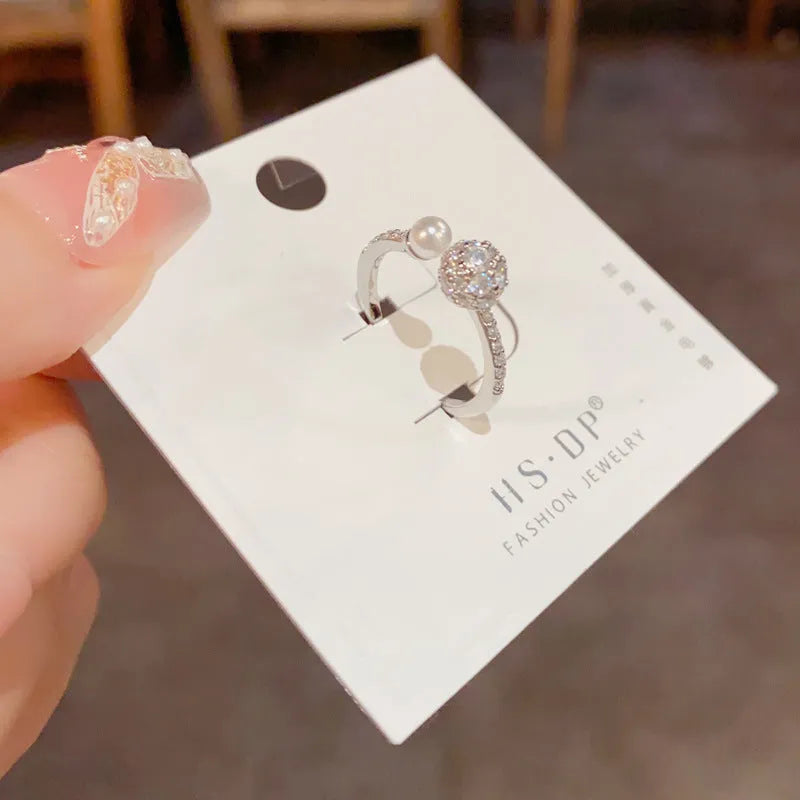 Open-end pearl ring with round zircon in gold plating on geometric copper band