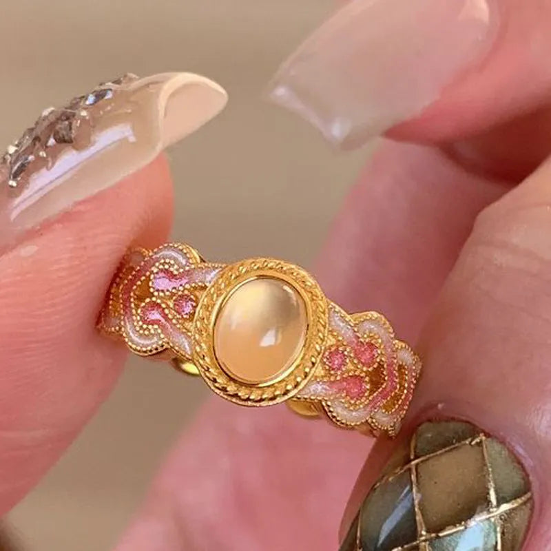 Openable geometric women's ring with pink crystal enamel on a gold plated copper band.