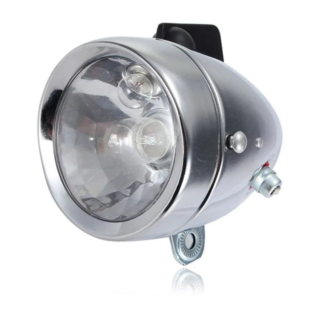 Silver aluminium bicycle dynamo light kit mounted on a bike fork for friction-powered lighting.