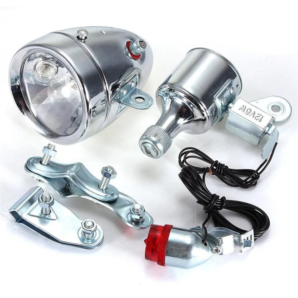 Silver aluminium bicycle dynamo light kit mounted on a bike fork for friction-powered lighting.