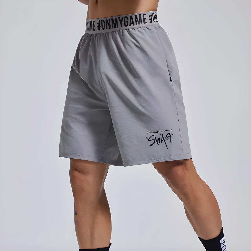 Men's loose cropped sports shorts in black with elastic waist and letter detail.