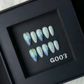 Blue plastic nail stickers and wearable nail armour pieces set on a white background.