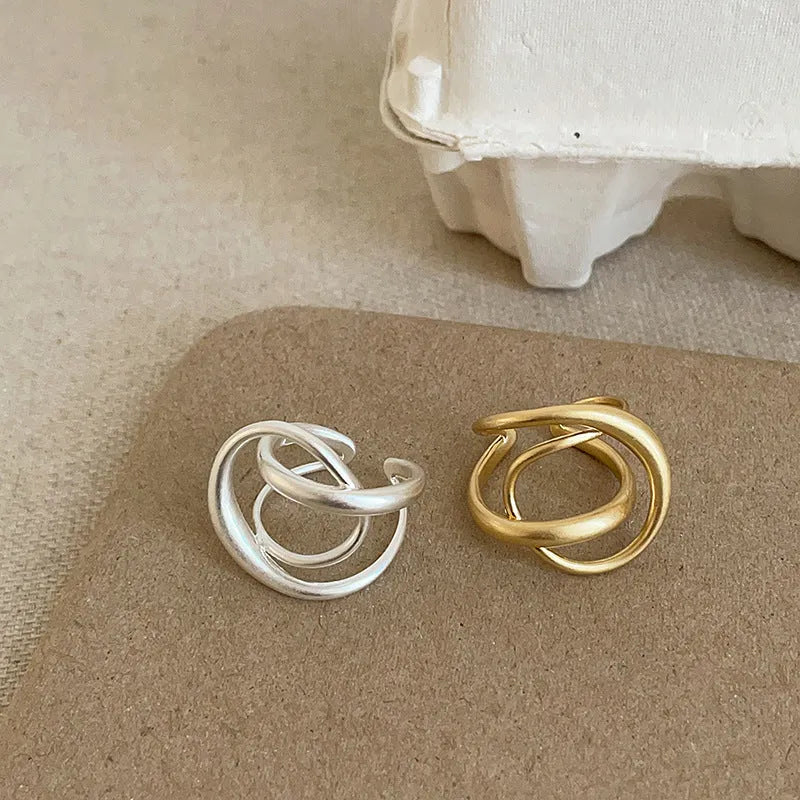 Three-dimensional interlaced geometric open ring in matte metal with gold plating
