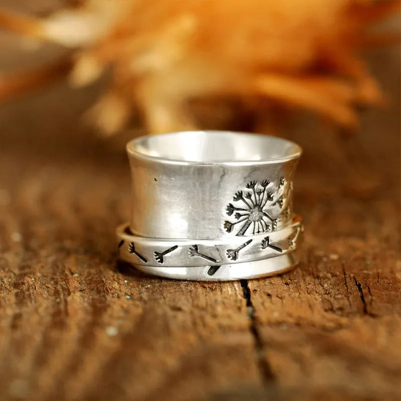 Silver rotatable floral fashion ring showing adjustable flower element on band
