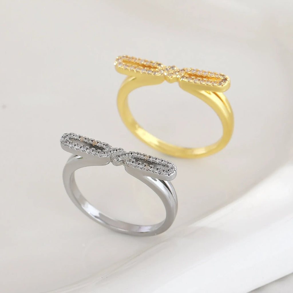 Fashion bowknot ring for women, copper with electroplated gold finish, bow shape on white background