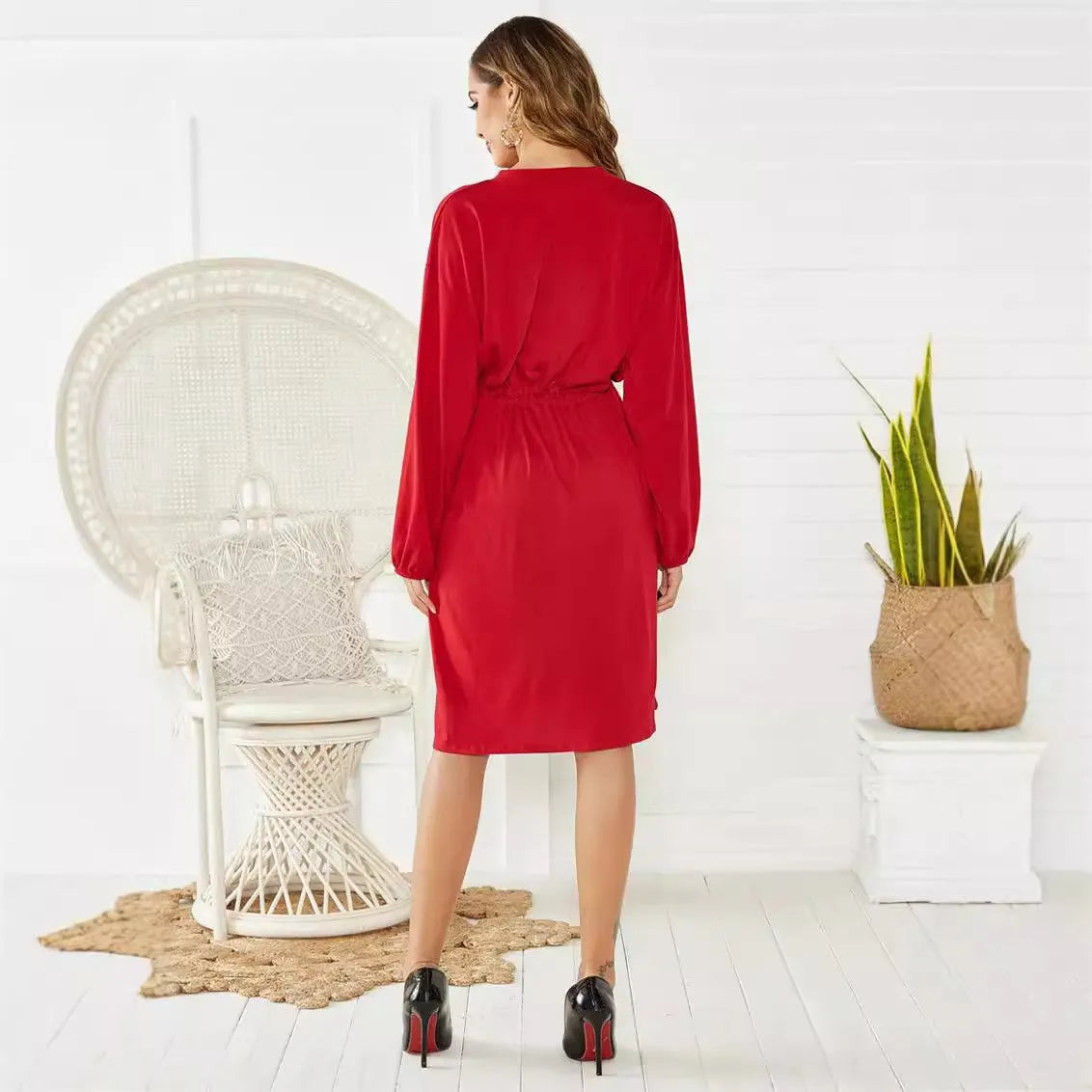 Women's black A-line dress with elastic waist, long sleeves, and a cinching belt on a mannequin.