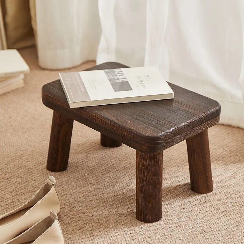 Distressed solid wood changing stool with bracket structure for hallway or living room.