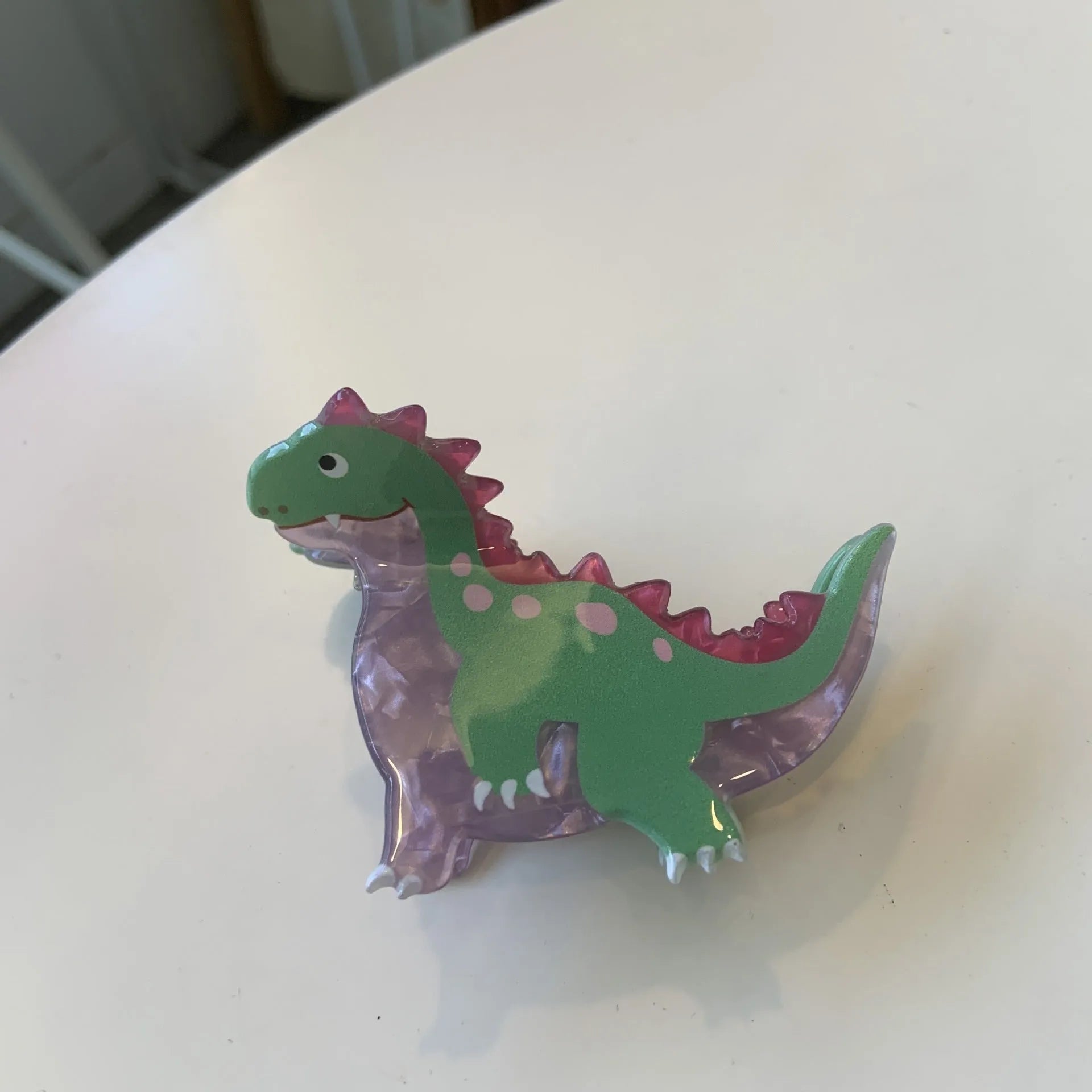 Dinosaur-themed acrylic jaw hair clip showing six colour variations with grip mechanism
