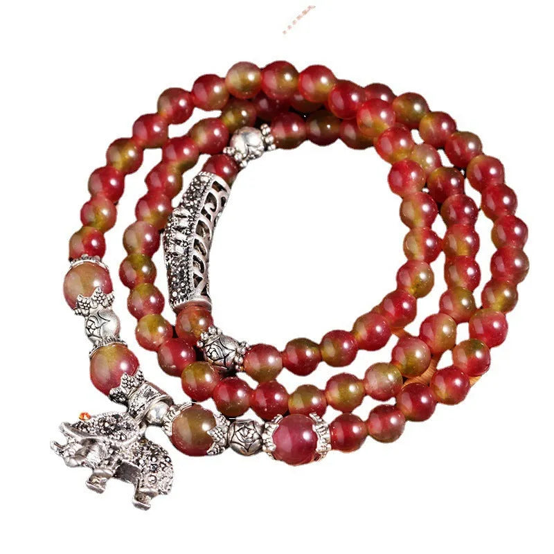 Handmade natural watermelon crystal bracelet with Chinese knots, shown in geometric national style.