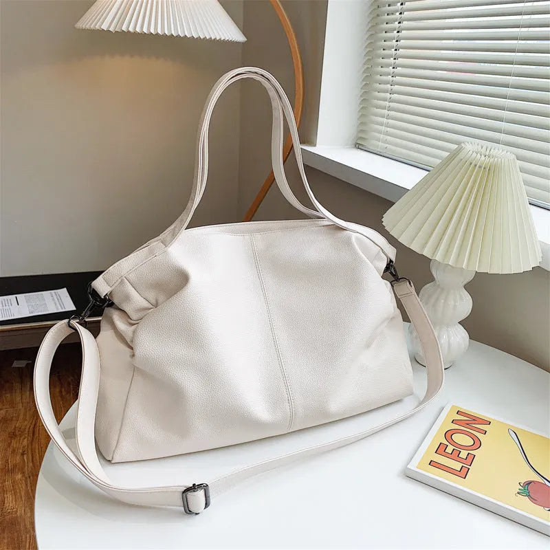 Large soft surface messenger bag showing horizontal square shape with adjustable shoulder strap and zip opening