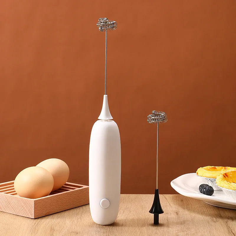Black and white handheld electric milk frother with blending function on kitchen counter