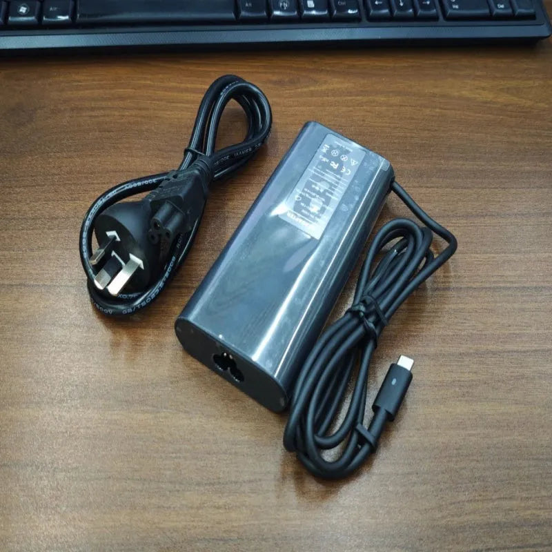 Black 65W Type-C laptop power adapter with six international power cords for worldwide charging