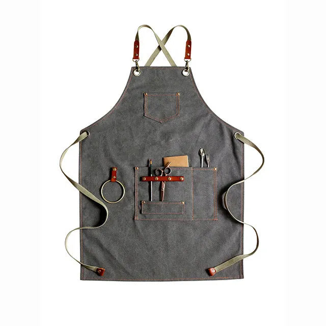 Canvas apron with cross-back straps in camel colour, shown laid flat