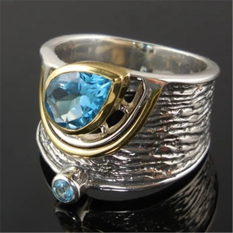 Close-up of a women's blue zircon alloy ring with a drop shape and Chinese-inspired design on a hand.
