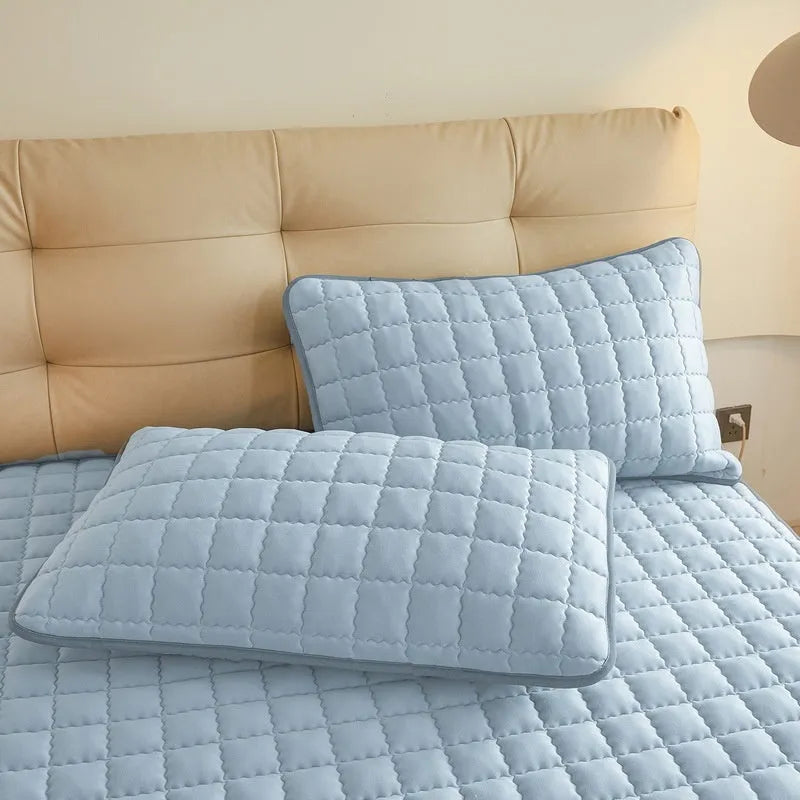 Blue washed cotton waterproof fitted sheet with elasticated edges on mattress.
