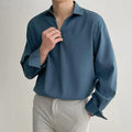 Men's loose lapel long sleeve shirt in a solid colour on a hanger.
