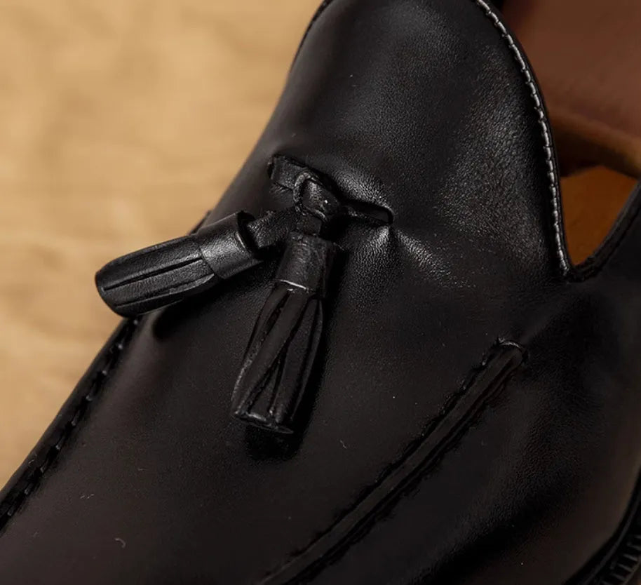Men's black genuine leather slip-on loafers showing polished finish and rubber sole