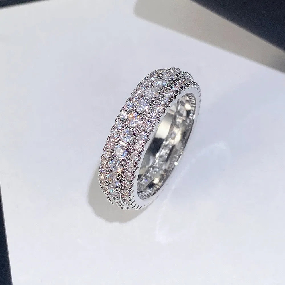 Geometric copper ring with triangle design and zircon stone inlay, shown in a choice of metallic finishes.