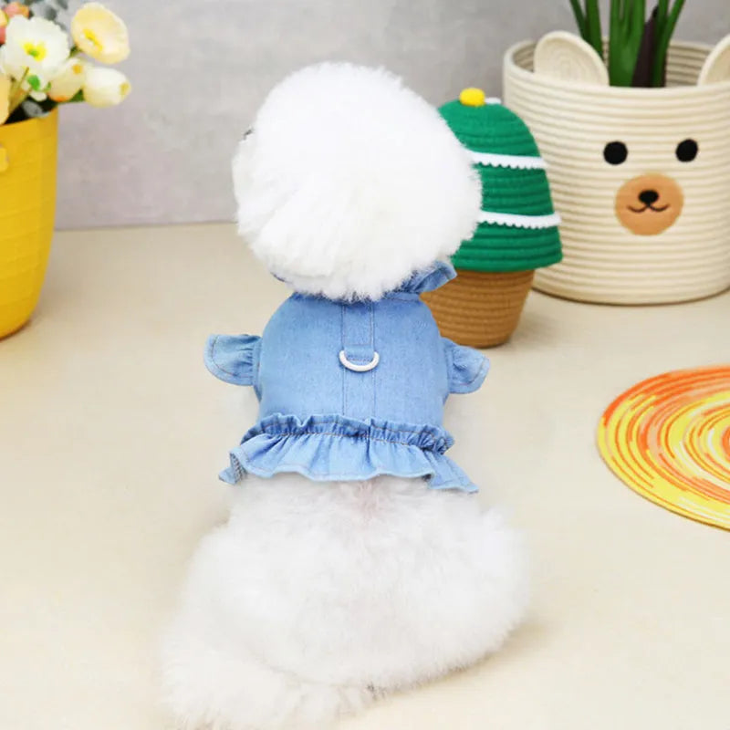 Blue denim dog dress with a ruffled vest design and a metal leash hook on the chest.