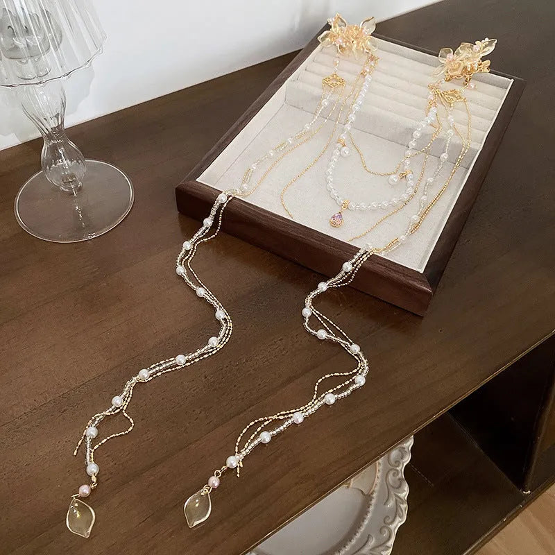 Gold grip hairpin with white pearl, clear diamond, flower decoration, and a long beaded tassel.