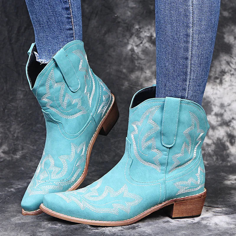 Women's blue embroidered cowboy boots with wedge heel and pointed toe on a white background.
