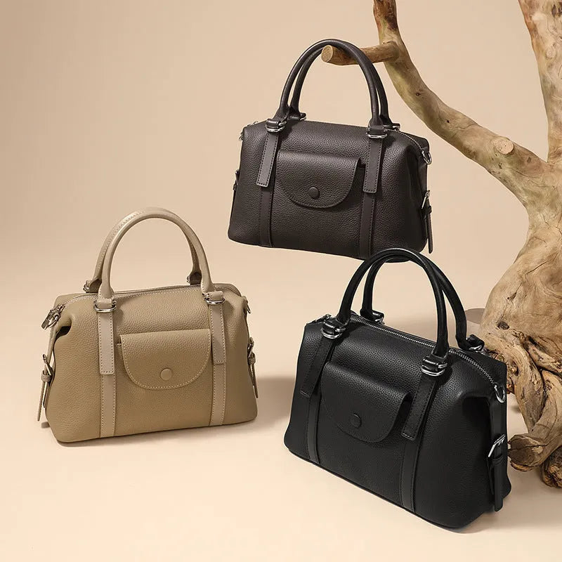 Genuine leather ladies handbag with lock detail in black, brown, or elephant grey.