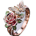 Close-up of an adjustable fairy style ring with a colourful oil-drip butterfly, rose, and leaf design in alloy.