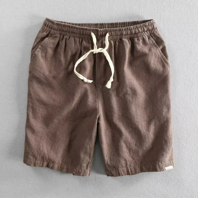 Man wearing loose-fit beige cotton linen casual shorts on a beach