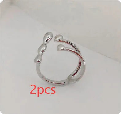 Open circle brass fashion ring with spherical beads in gold tone on a hand.