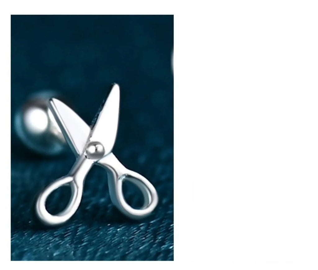 A pair of silver ear nail earrings with a mini scissors screw design and screw-back closures.