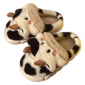 White cartoon cow plush slippers for women with a textured anti-slip sole.