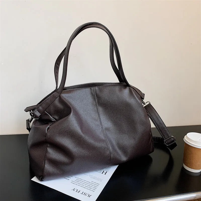 Large soft surface messenger bag showing horizontal square shape with adjustable shoulder strap and zip opening