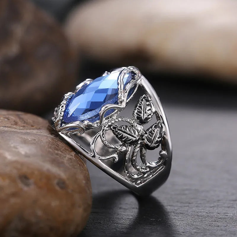 Blue crystal inlaid in a geometric horse eye shape on an alloy women's ring.
