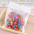 Assortment of fifty small cartoon-shaped rubber erasers in fruit and animal designs.