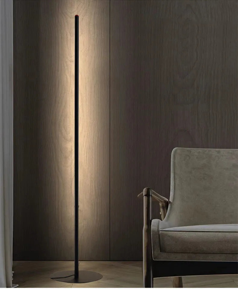 Vertical aluminium alloy floor lamp with a simple modern design, shown in a living room setting.