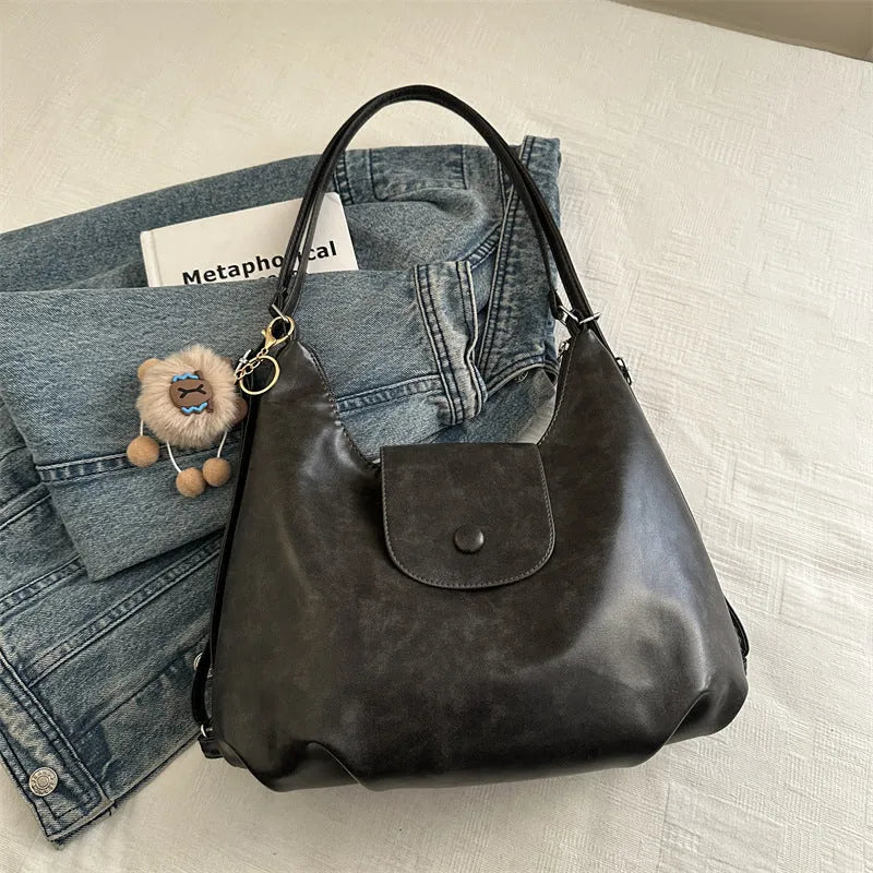 Textured PU leather commuter shoulder backpack in horizontal square shape with single strap and mobile phone compartment