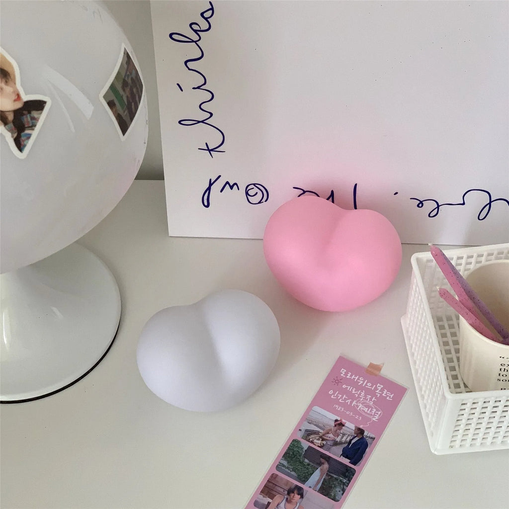 Pink and white vinyl atmosphere desk lamps in small and large sizes with warm LED glow.