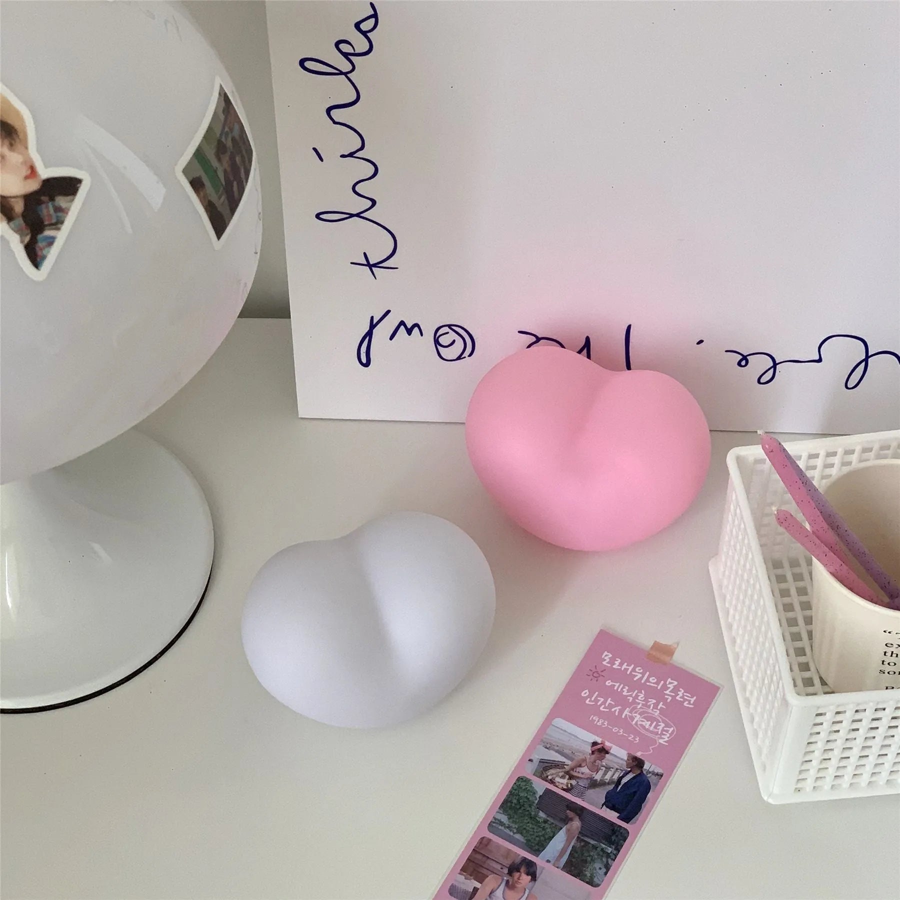Pink and white vinyl atmosphere desk lamps in small and large sizes with warm LED glow.