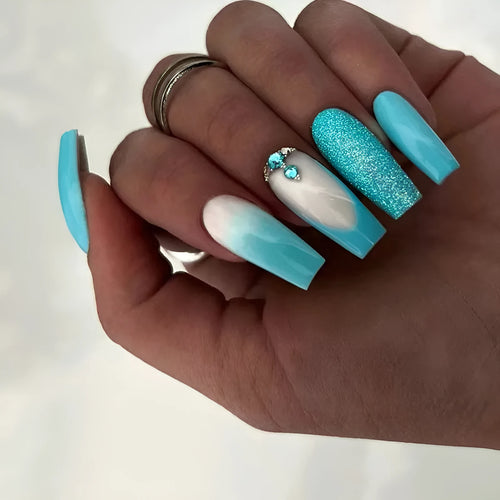 Long ballet shape false nails with solid blue colour and smart blue diamond design, shown with adhesive glue.