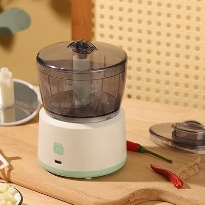 Mini electric meat grinder in light green with transparent cup and stainless steel blades