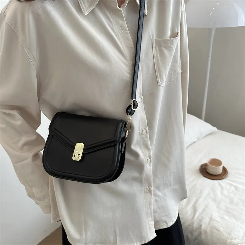 Soft black PU messenger bag with clamshell opening and niche texture, shown open.