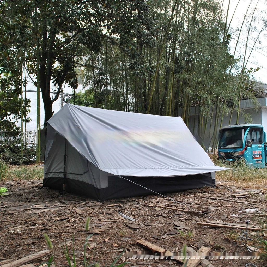 Brown or white A-frame pole-free cabin tent erected with hiking cane supports